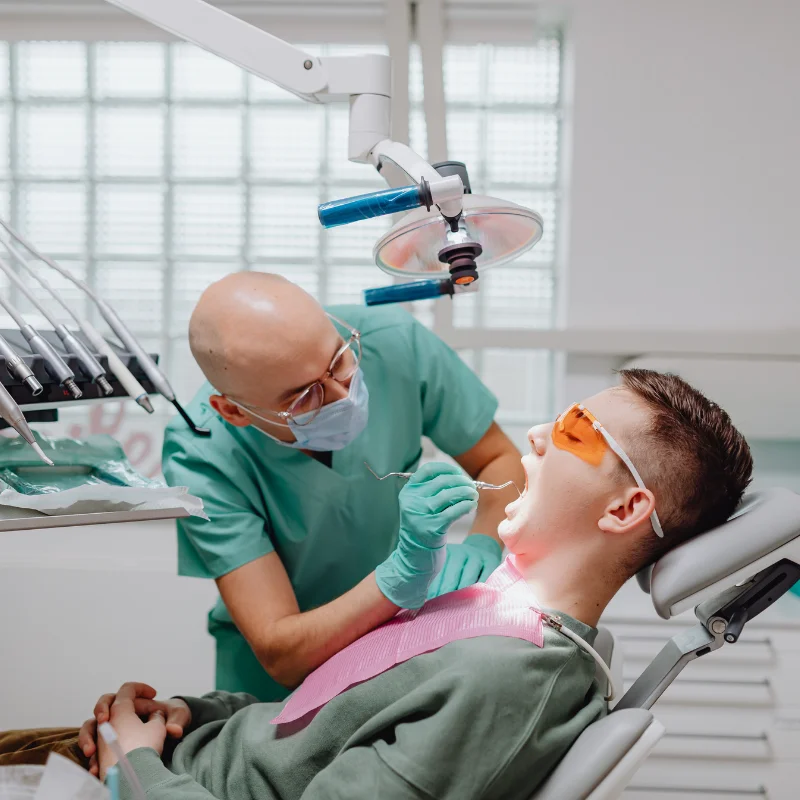 Dentist performing an oral surgery procedure while treating a patient in a dental chair at Riverfront Dental in Cambridge Ontario