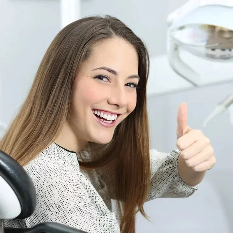Patient giving thumbs up after dental implant treatment at Riverfront Dental Cambridge